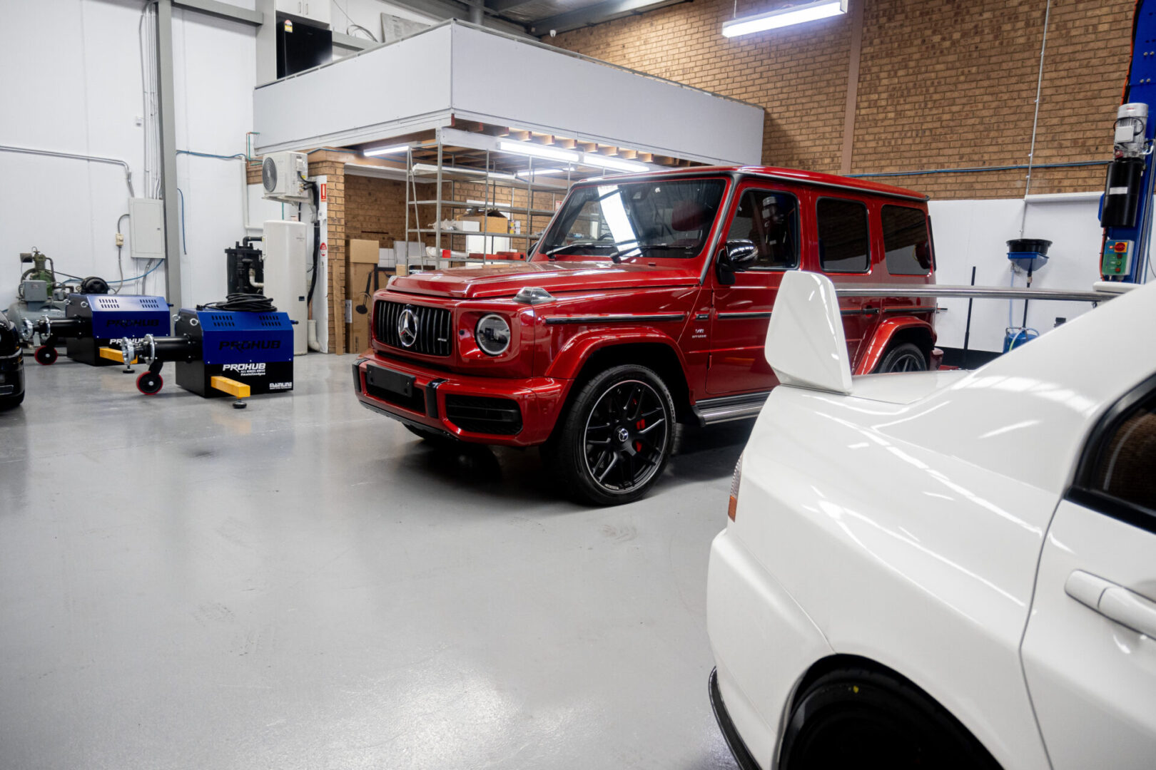 A red mercedes benz parked in a garage.